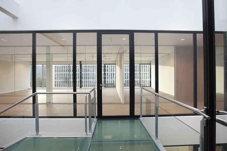 Moderne kantoorruimte aan de De Boelelaan met glazen wanden, houten vloer en glazen loopbrug.